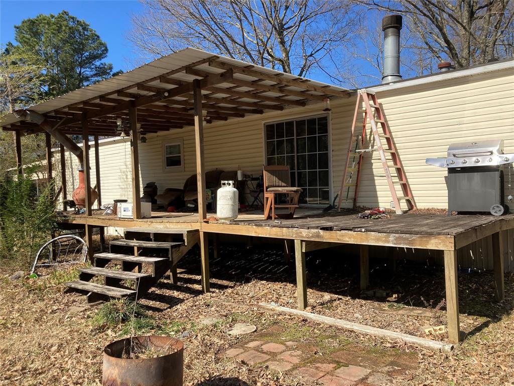 9515 Caddo Lake Road Mooringsport, LA 71060 - Photo 5 of 12 a view of a patio with table and chairs under an umbrella