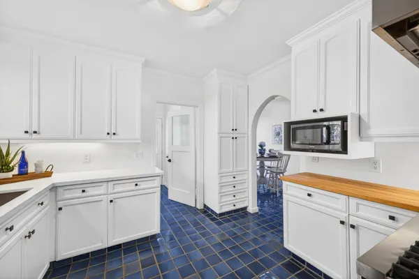 a kitchen with white cabinets and appliances