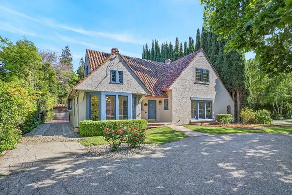 a front view of a house with a yard and trees