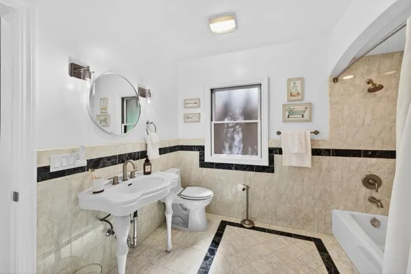 a bathroom with a tub sink and mirror