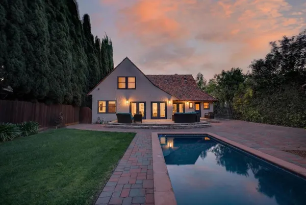 a view of yard with swimming pool and wooden fence