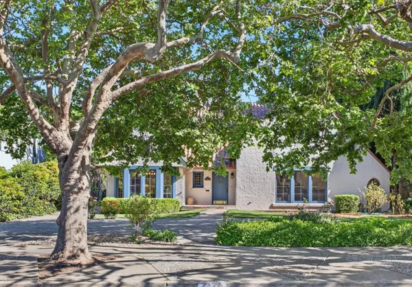 a front view of a house with a tree