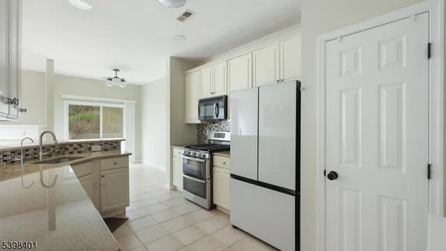 a kitchen with stainless steel appliances granite countertop a refrigerator stove and sink