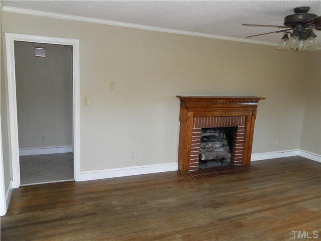 136 Cavel Chub Lake Road Roxboro, NC 27574 - Photo 4 of 11 a view of an empty room with wooden floor and a fireplace
