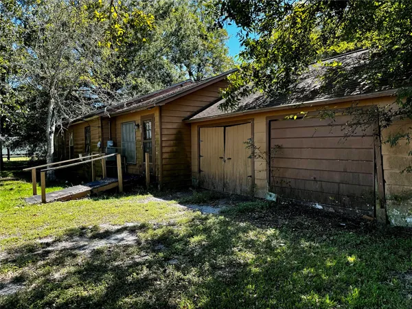 a view of backyard with wooden fence and a large tree