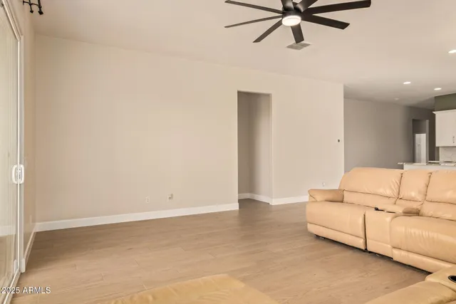 a living room with furniture and a ceiling fan