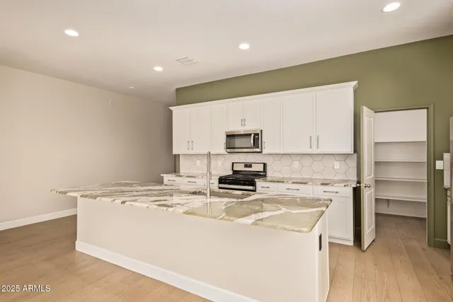 a kitchen with kitchen island a stove a sink and a refrigerator