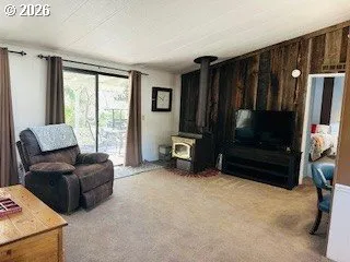 a living room with furniture and a dining table next to a window