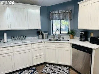 a kitchen with white cabinets and black appliances
