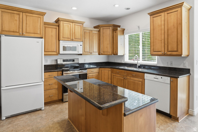 2190 750 West Perry, UT 84302 - Photo 16 of 42 Kitchen featuring granite countertops, wood cabinetry, stainless steel range, and a central island