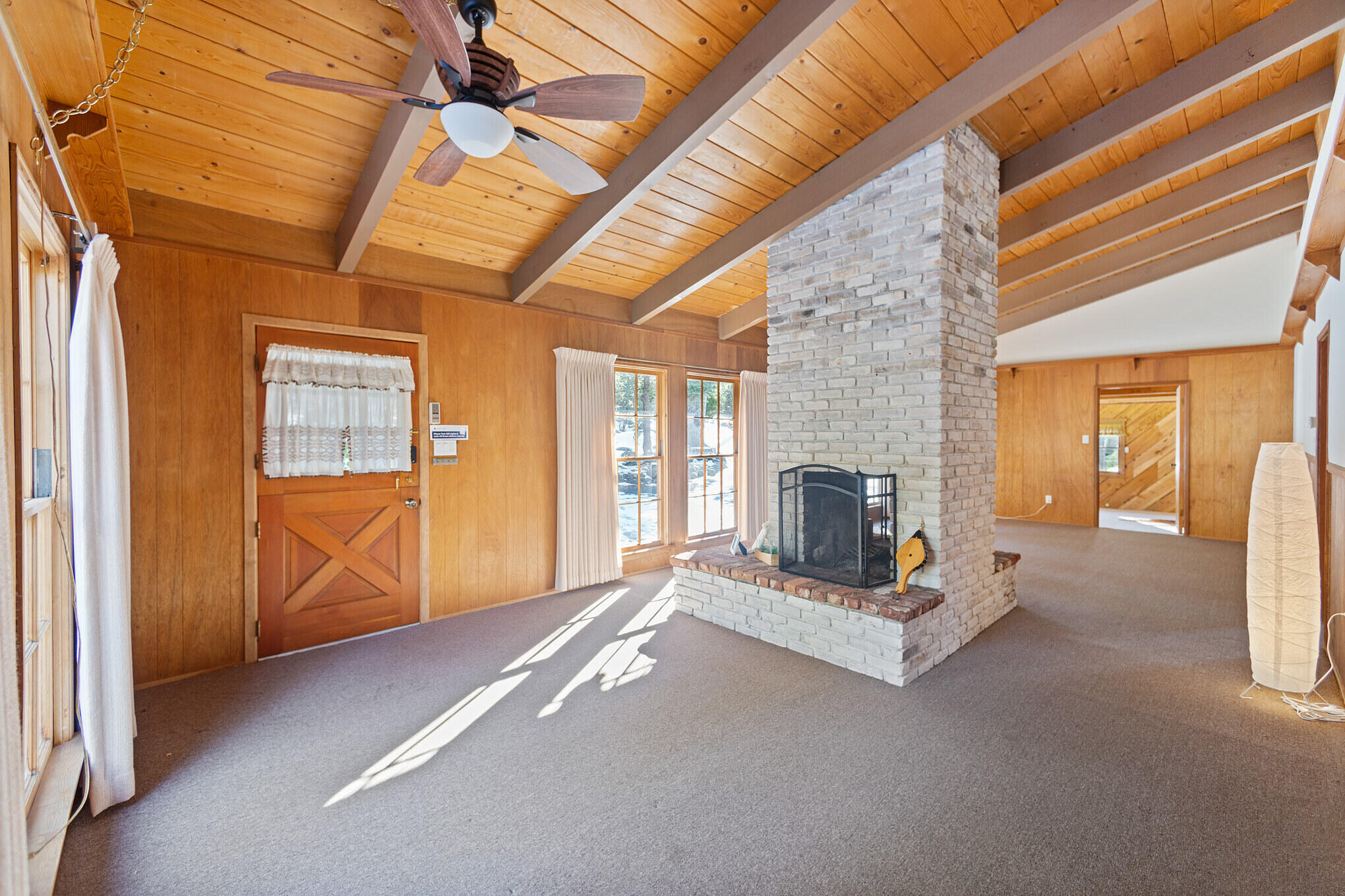 25465 Seneca Road Idyllwild, CA 92549 - Photo 13 of 38 a view of an empty room with wooden floor and a fireplace