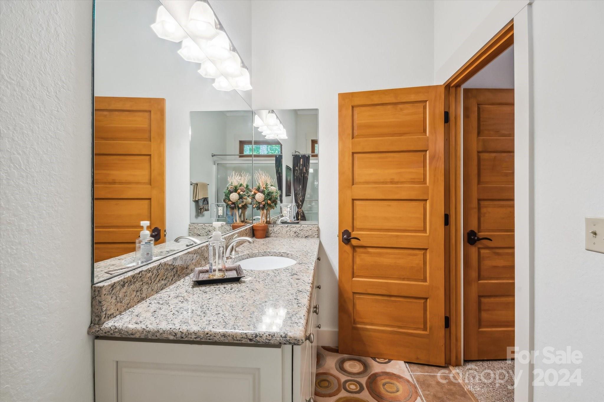 39 Elms Rest Cullowhee, NC 28723 - Photo 24 of 45 a bathroom with a granite countertop sink and a mirror