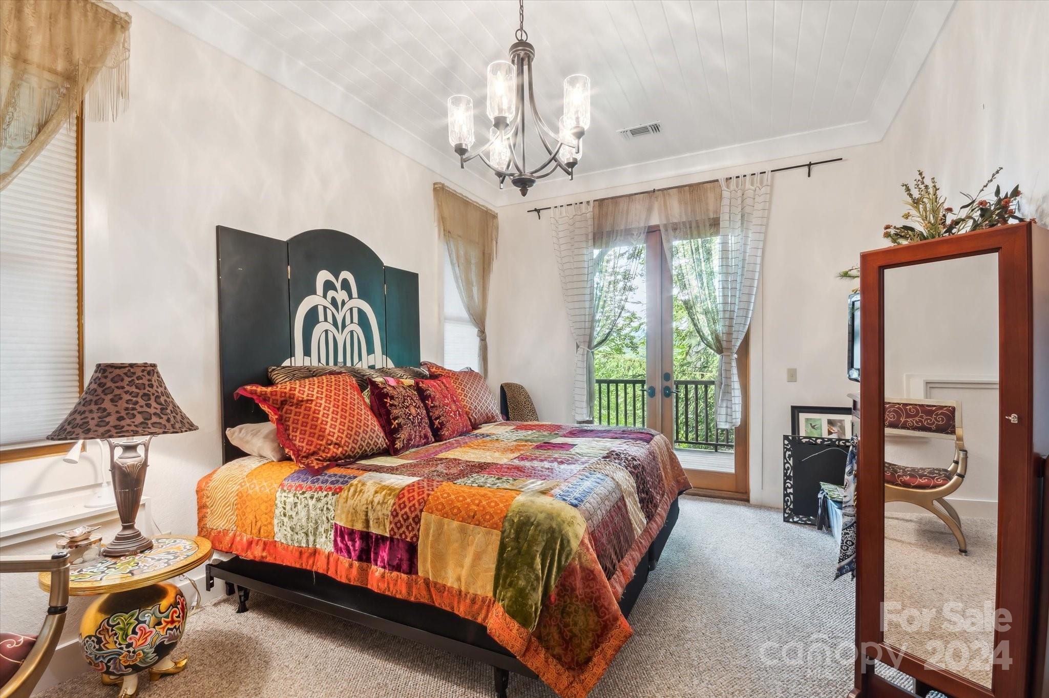 39 Elms Rest Cullowhee, NC 28723 - Photo 32 of 45 a bedroom with a bed and a chandelier