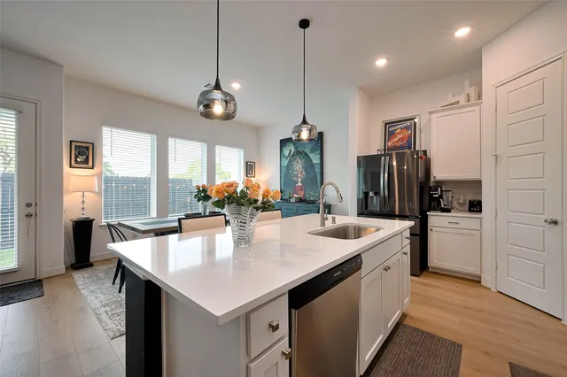 a kitchen with stainless steel appliances granite countertop stove refrigerator and wooden floor