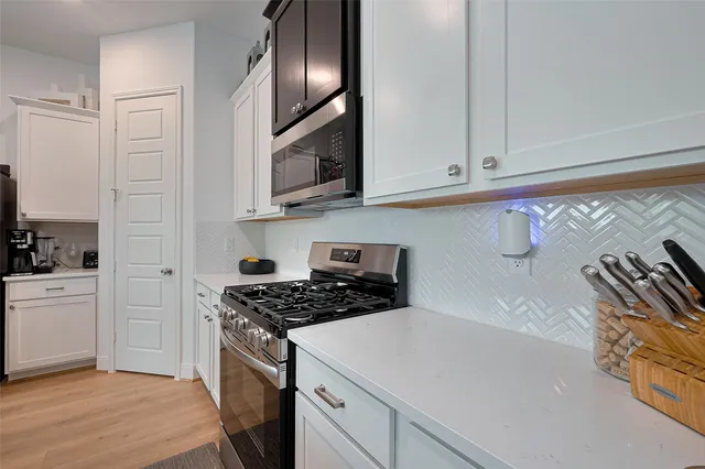 a kitchen with stainless steel appliances granite countertop a sink a stove and a refrigerator