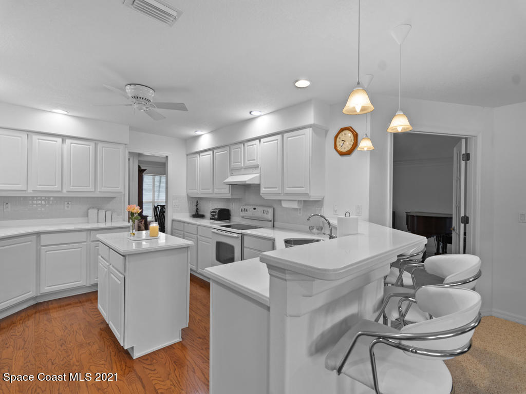 2770 Weber Road Malabar, FL 32950 - Photo 8 of 23 a kitchen with a sink dishwasher a stove a dining table and chairs