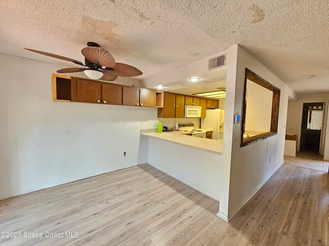 a view of a kitchen with a sink and wooden floor