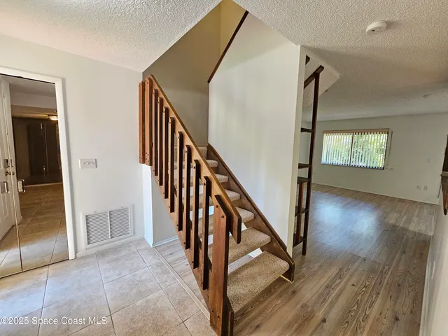 a view of an entryway with wooden floor and stairs