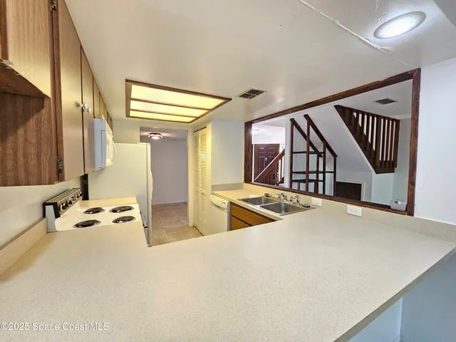 a kitchen with stainless steel appliances granite countertop a sink and wooden floors