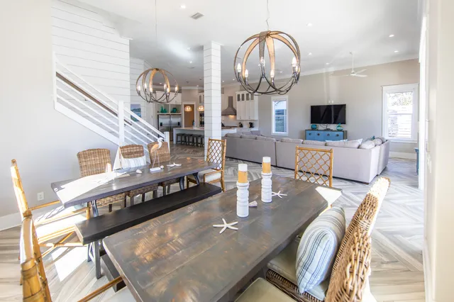 a kitchen with stainless steel appliances a dining table chairs and stove