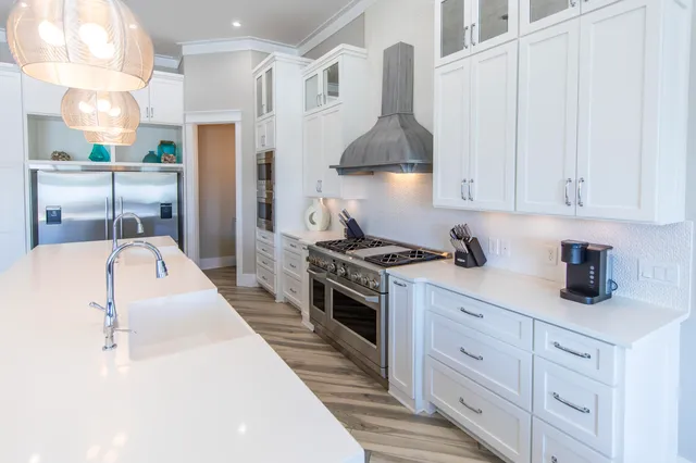 a open kitchen with stainless steel appliances kitchen island granite countertop a stove a sink a dining table and chairs with wooden floor