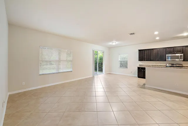 a view of a kitchen with a sink and an empty room