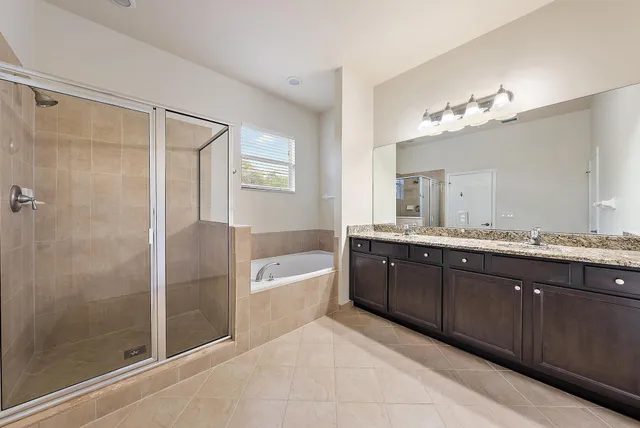 a spacious bathroom with a tub sink shower and mirror