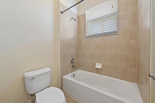 a white toilet sitting next to a bath tub