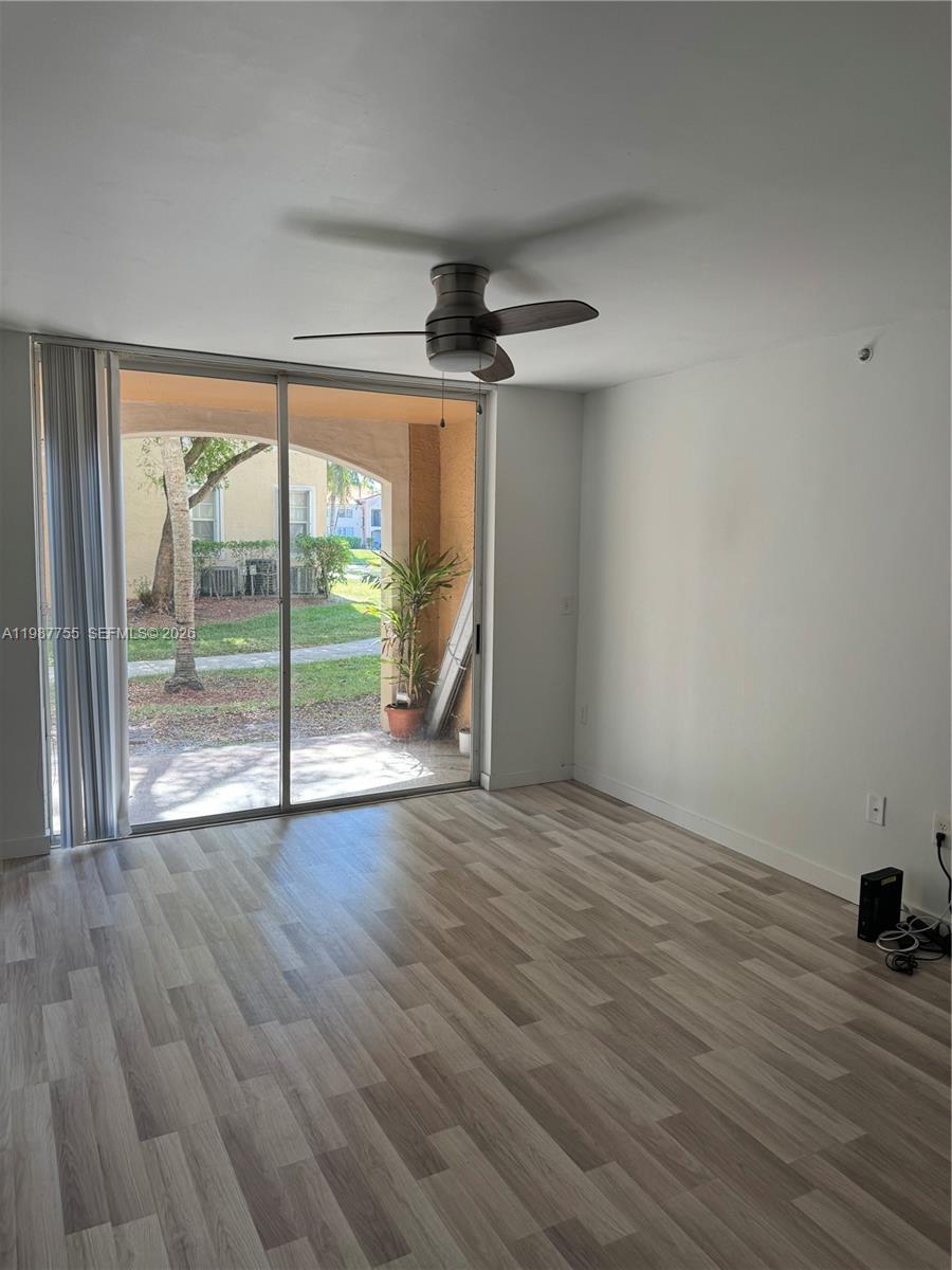 2071 Renaissance Boulevard, Unit 104 Miramar, FL 33025 - Photo 5 of 17 wooden floor in an empty room with a window