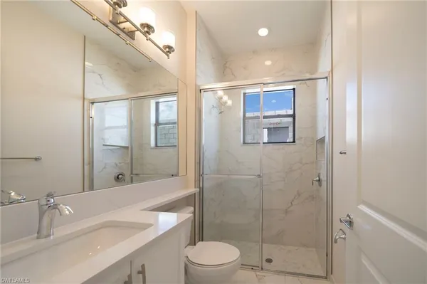 a spacious bathroom with a sink a large mirror and a shower