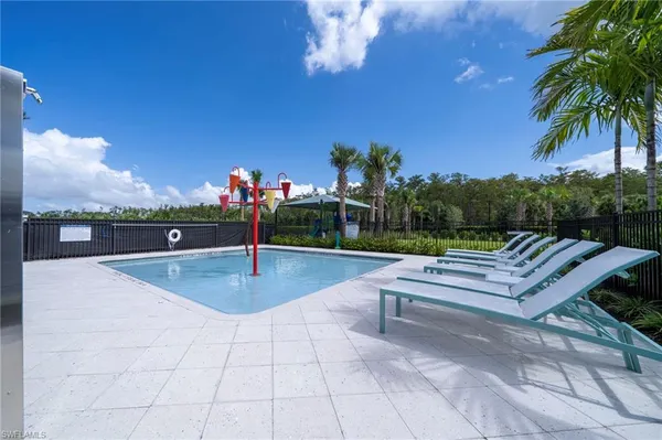 a view of a swimming pool with a table and chairs under an umbrella