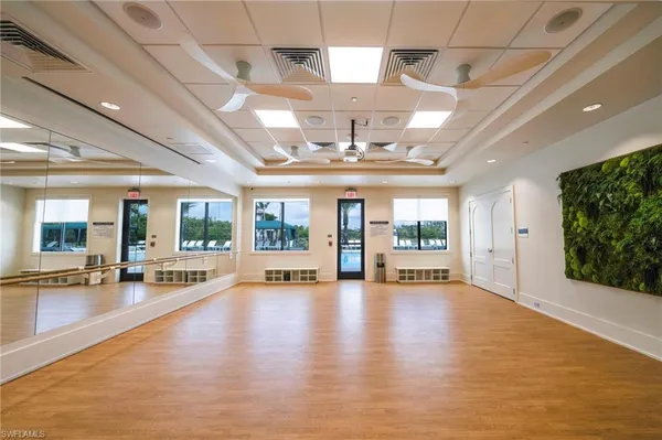 a view of an empty room with wooden floor and windows