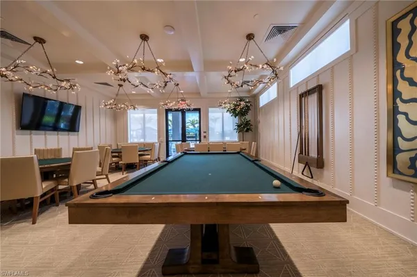 a room with pool table flat screen tv and windows