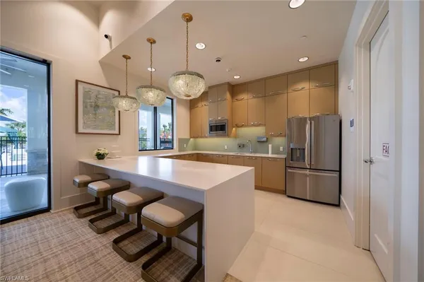 a kitchen with stainless steel appliances kitchen island granite countertop a sink a stove and a refrigerator