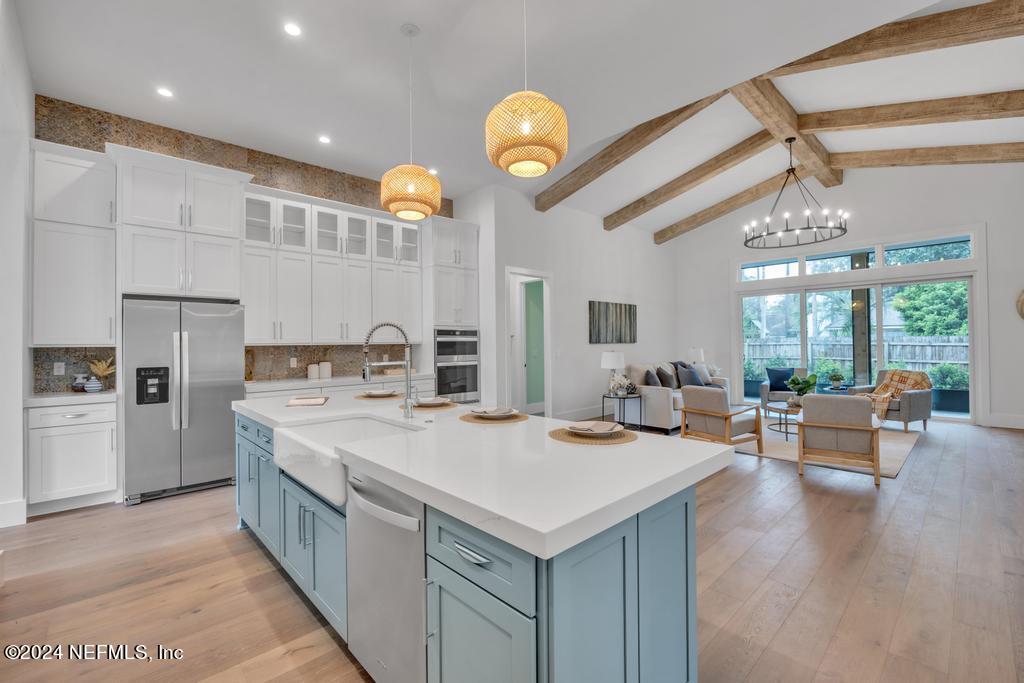 a large kitchen with kitchen island a large island in it