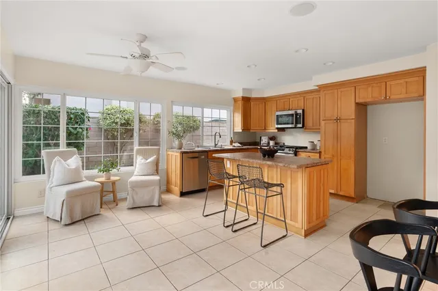 a kitchen with stainless steel appliances kitchen island granite countertop a stove a sink a dining table and chairs