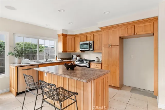 a kitchen with stainless steel appliances granite countertop a sink refrigerator and microwave