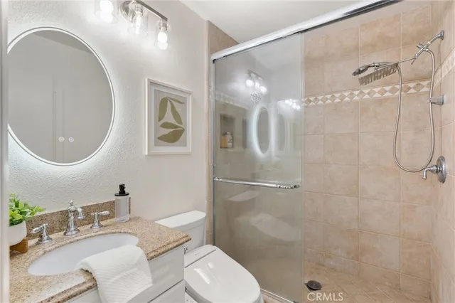 a bathroom with a sink toilet a mirror and shower