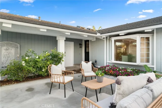 a view of a patio with couches table and chairs and potted plants
