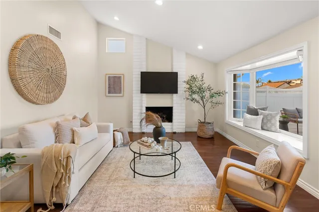 a living room with furniture a fireplace and a large window