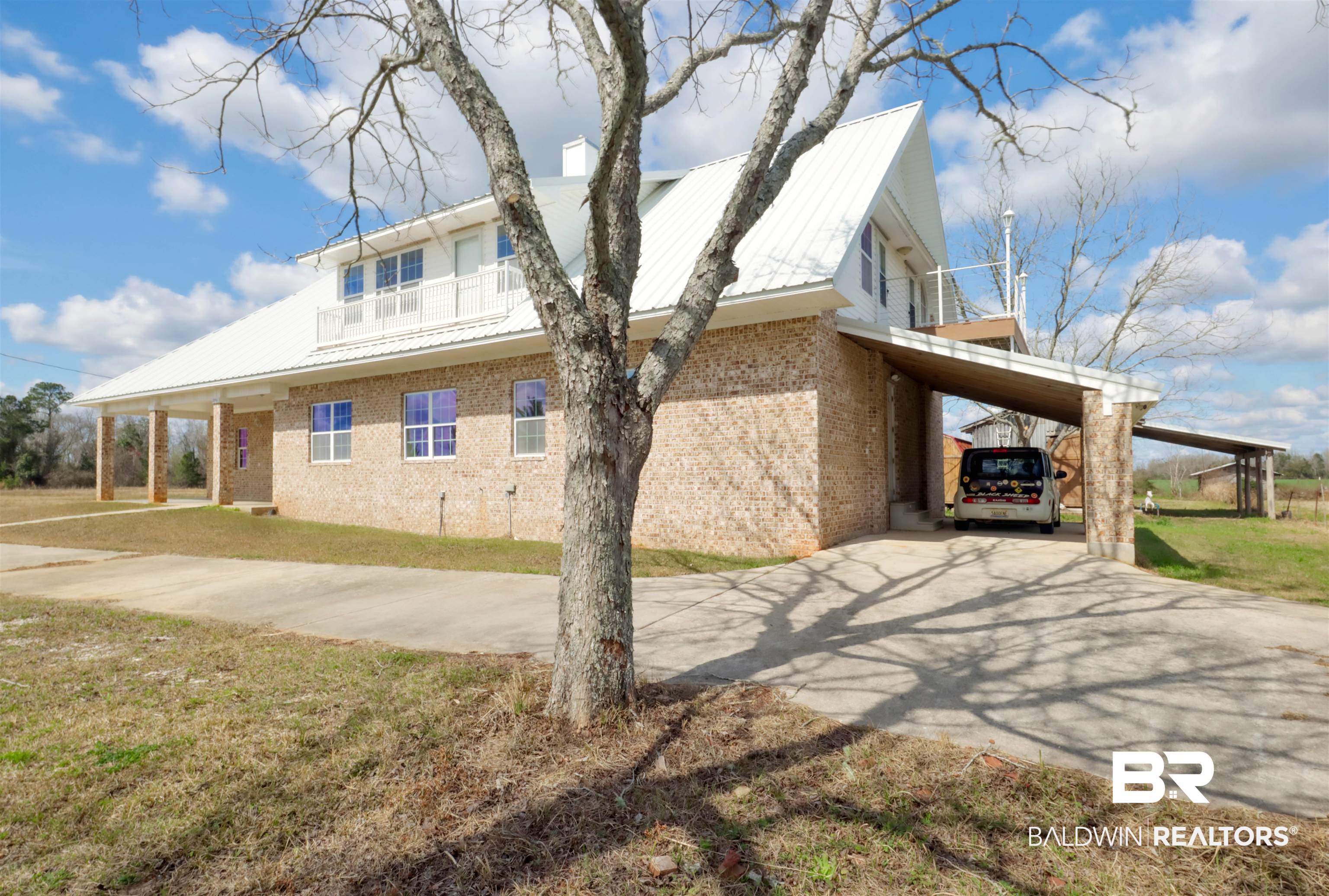 28461 Gardner Road Elberta, AL 36530 - Photo 34 of 46 View of home's exterior with a carport, a metal roof, brick siding, a yard, and driveway