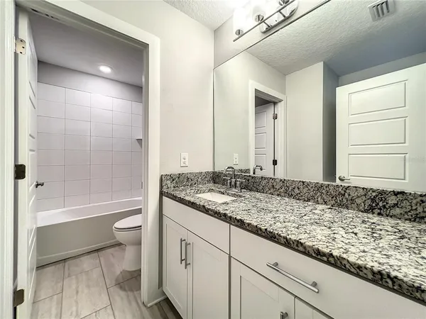 a white toilet sitting next to a bath tub and a shower