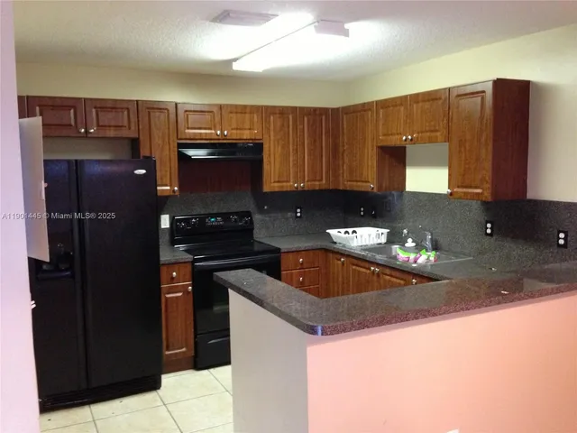 a kitchen with granite countertop a sink and a stove top oven