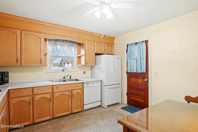 a kitchen with appliances a sink and cabinets