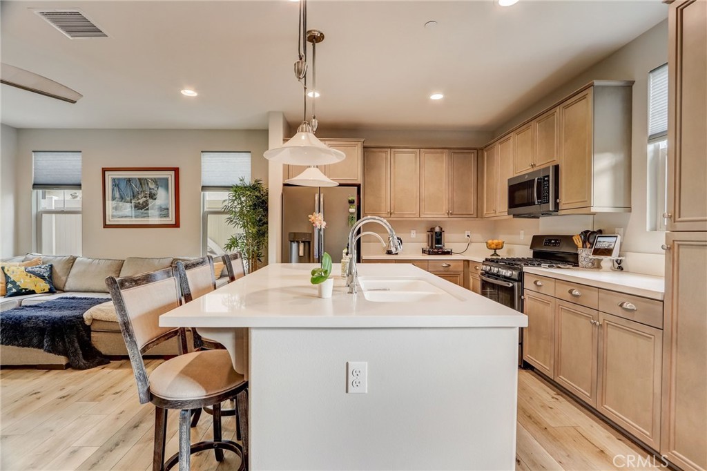 193 Stonegate Road Camarillo, CA 93010 - Photo 12 of 39 a kitchen with sink refrigerator dining table and chairs