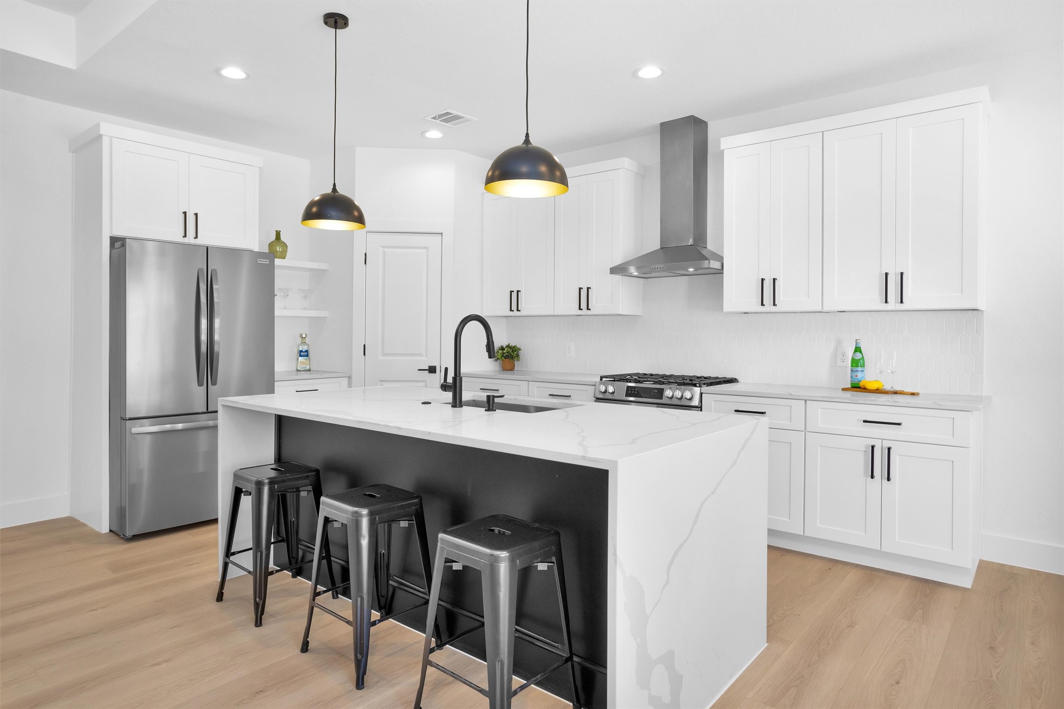 6334 Roughlock Street Houston, TX 77016 - Photo 7 of 24 a kitchen with kitchen island white cabinets and stainless steel appliances