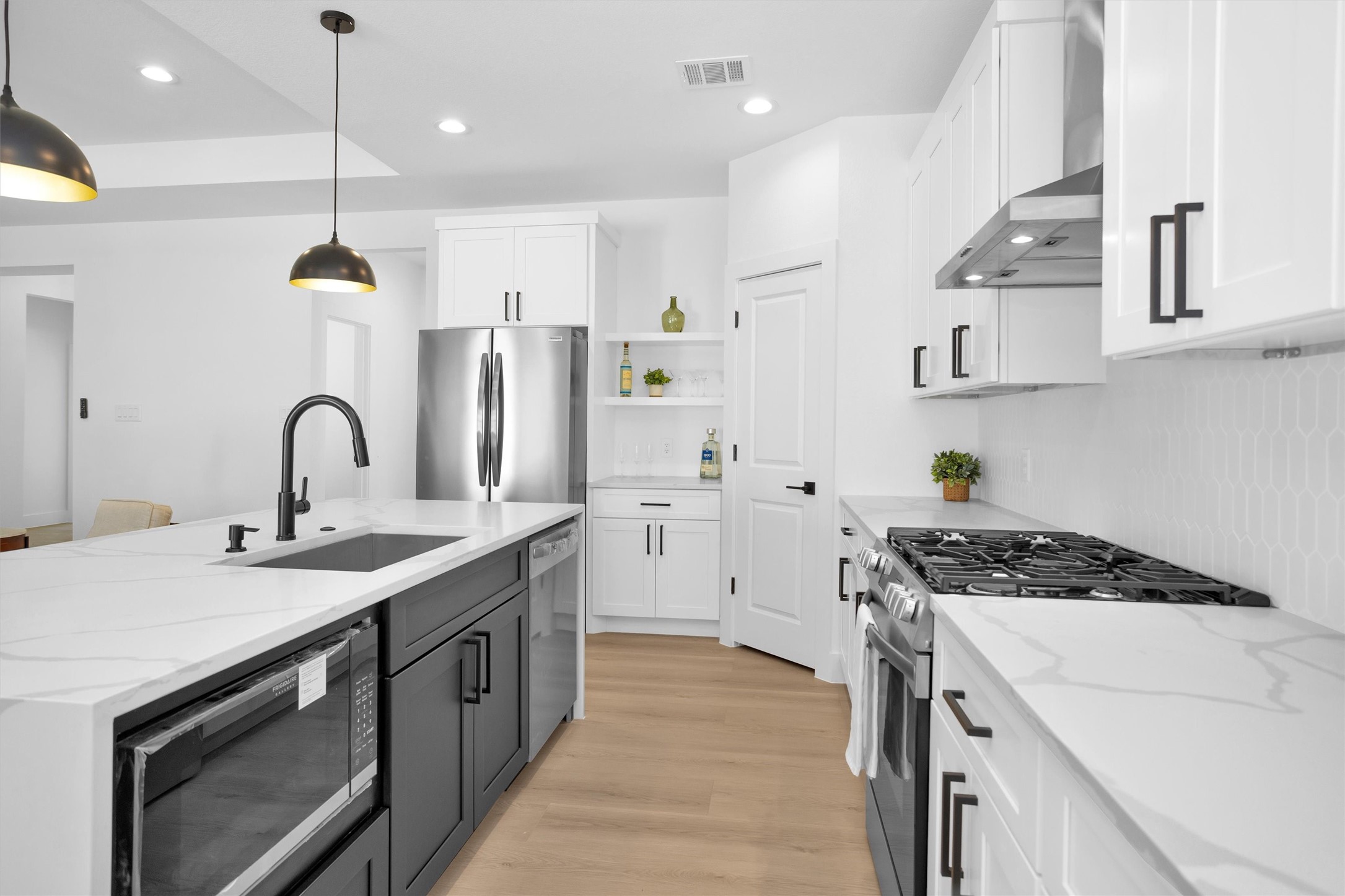 6334 Roughlock Street Houston, TX 77016 - Photo 9 of 24 a kitchen with kitchen island stainless steel appliances a sink a stove and a wooden floors