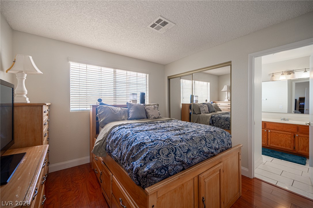 718 Rusty Spur Drive Henderson, NV 89014 - Photo 42 of 50 Hardwood floors and generous closet space define this cozy bedroom with private bath access.