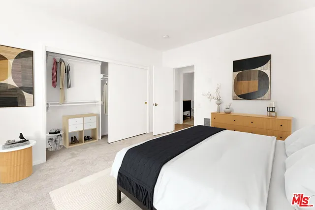 a spacious bedroom with a bed a mirror and desk