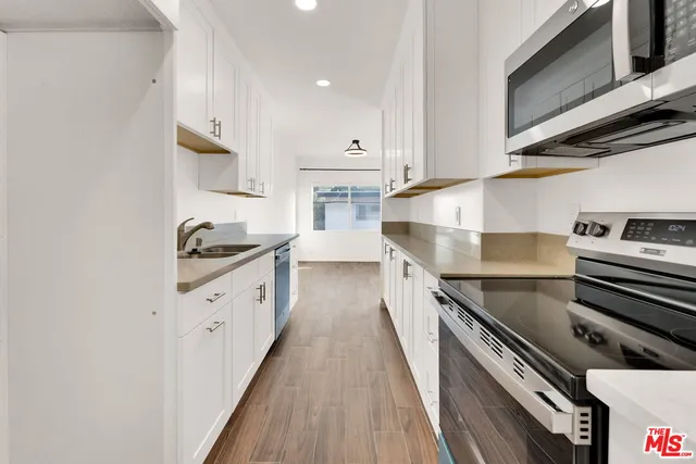 a kitchen with granite countertop a stove and a sink